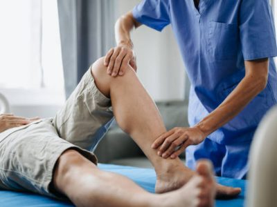 Close up of Physiotherapist working with patient on the bed in clinic