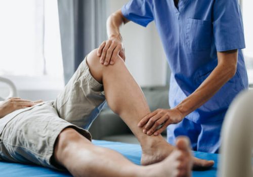 Close up of Physiotherapist working with patient on the bed in clinic